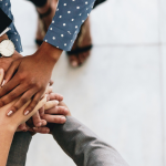 group of business people with hands stacked on top of each other